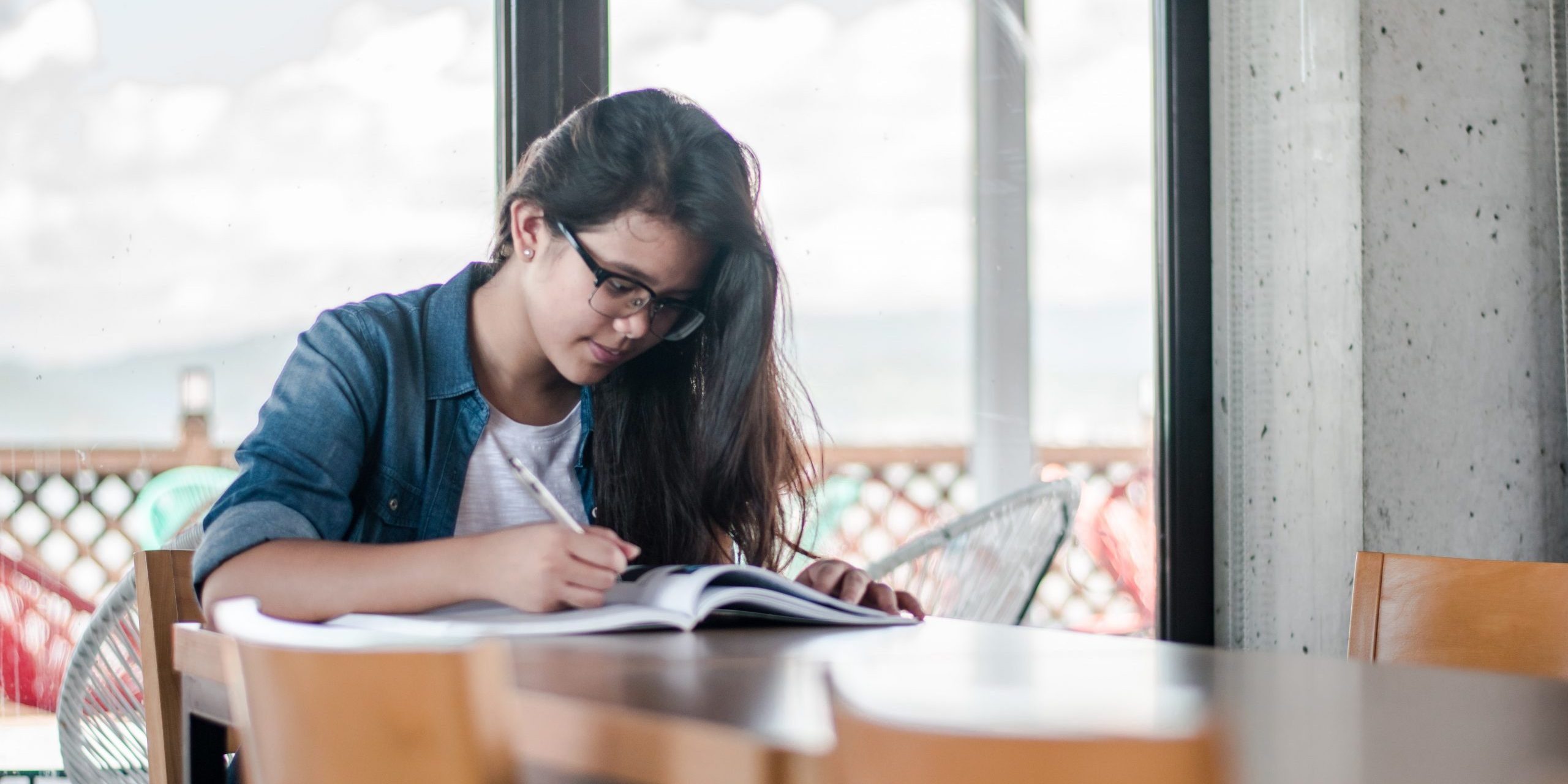 A woman works on a workbook as part of a marine conservation internship