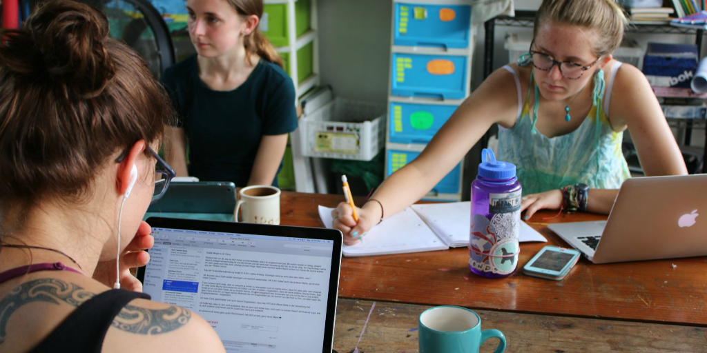 Group of students studying together on laptops at a table