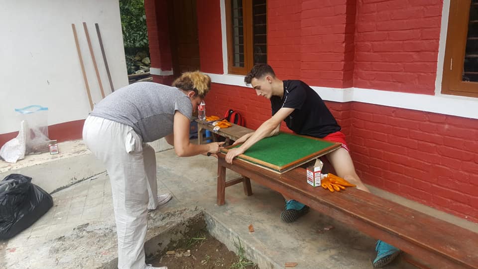 Volunteers performing construction tasks to provide schoools with the desks they need