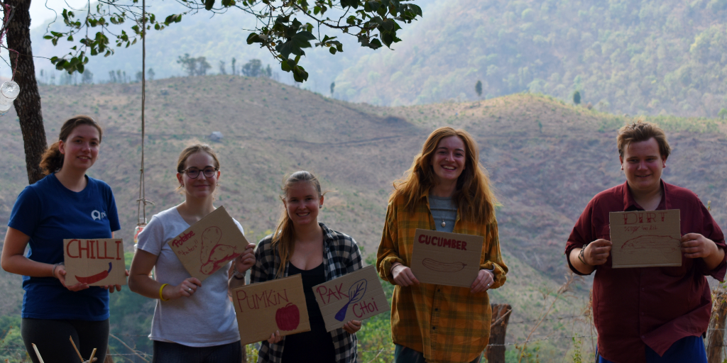 The environmental volunteers of GVI hold signs of what was planted in the community garden. 