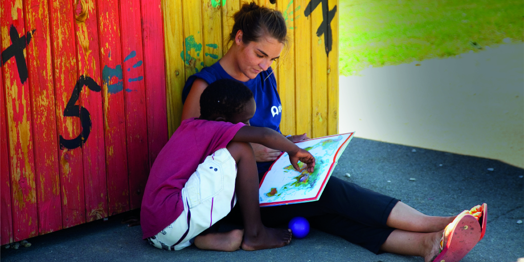 A Cape Town based GVI participant helps a child read. 