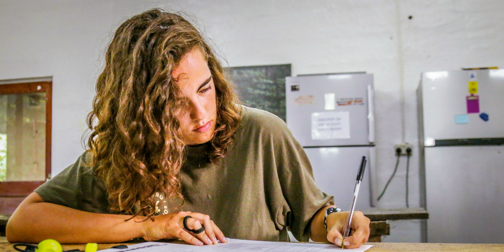 A lady writes notes during her work experience program. 