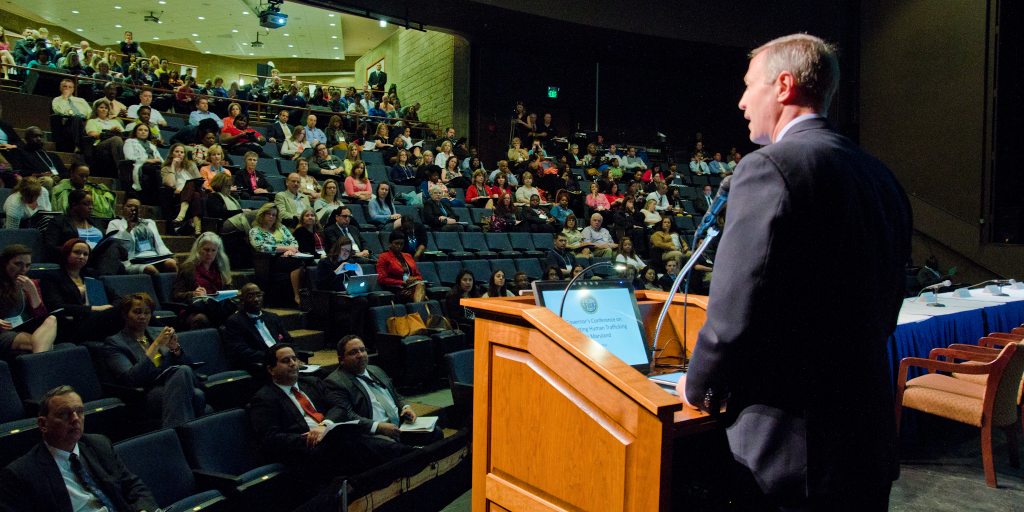 A man speaks at a human trafficking conference. 