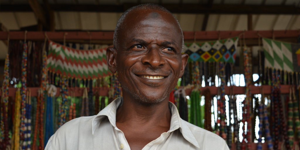 A Ghanaian man standing in front of his jewellery stall. 